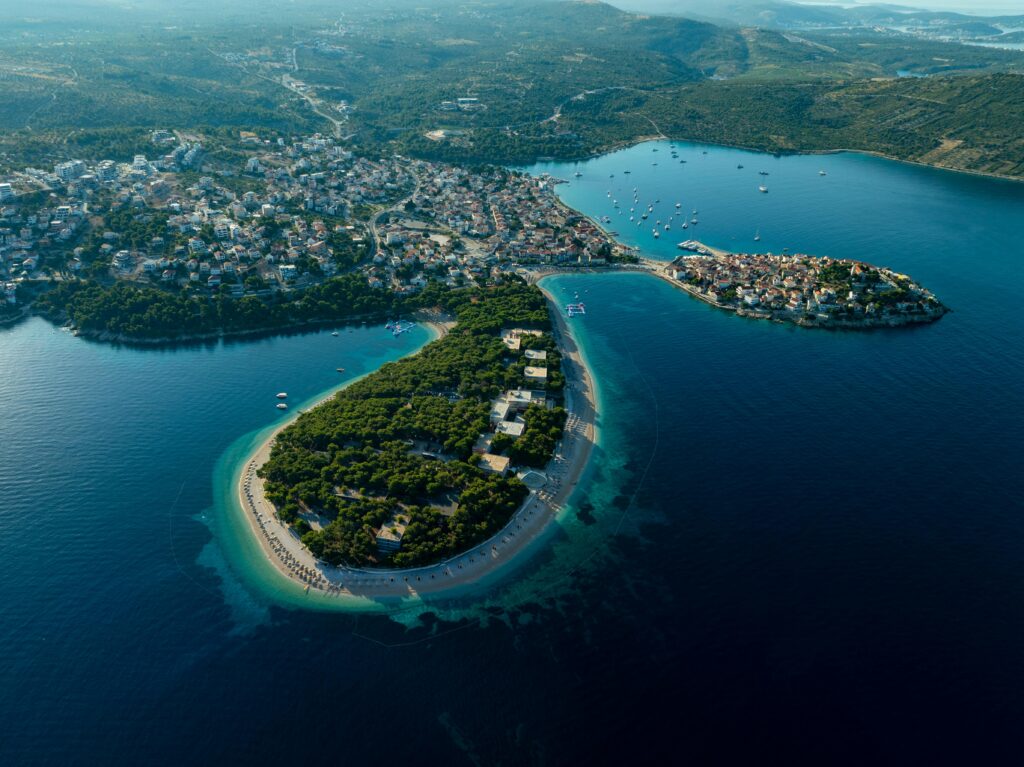 Stunning aerial view of Primošten peninsula, showcasing vibrant coastal scenery and azure waters.