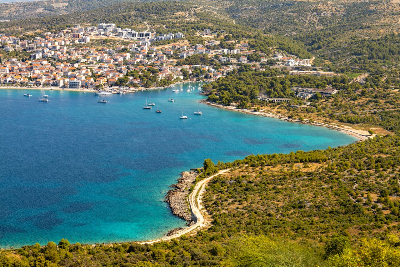 A stunning aerial view of Primošten's coastline, showcasing its turquoise waters and lush greenery.